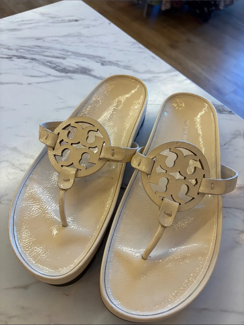 Tory Burch Patent Logo Thong Sandals in Light Beige with a chunky heel.